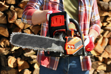 Man with modern saw on sunny day, closeup