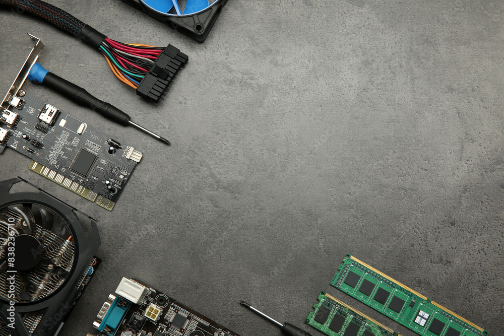 Fototapete graphics card and other computer hardware on grey textured table, flat lay. space for text