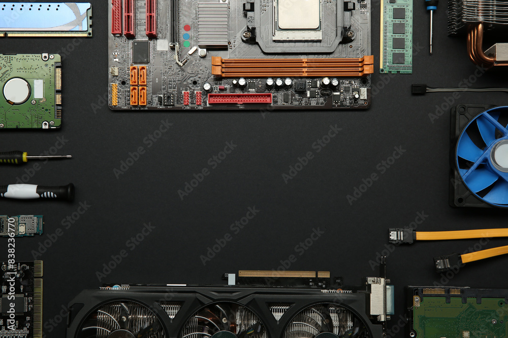 Fototapete frame of graphics card and other computer hardware on black background, flat lay. space for text
