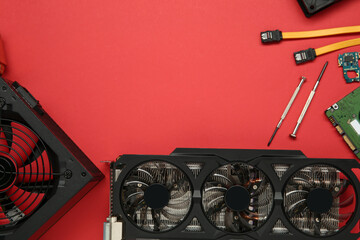 Graphics card and other computer hardware on red background, flat lay. Space for text