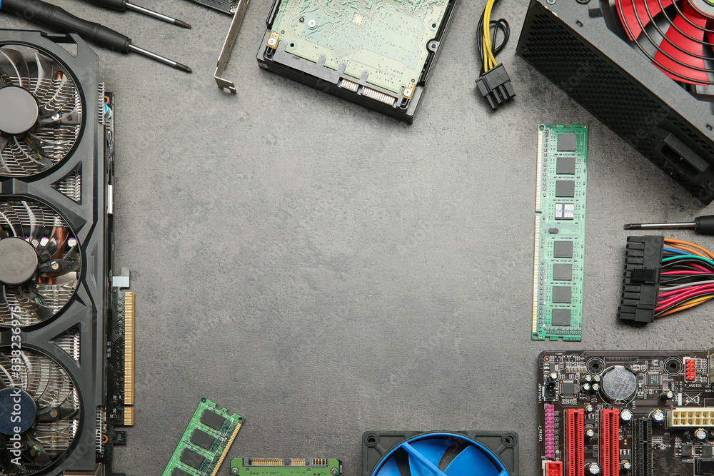 Poster frame of graphics card and other computer hardware on grey textured table, flat lay. space for text