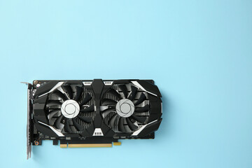 Computer graphics card on light blue background, top view. Space for text
