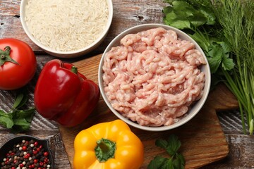Making stuffed peppers. Ground meat and other ingredients on wooden table, flat lay