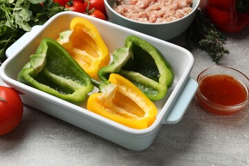 Making stuffed peppers. Vegetables and ground meat on grey table