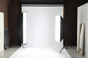 White photo background and professional lighting equipment in studio