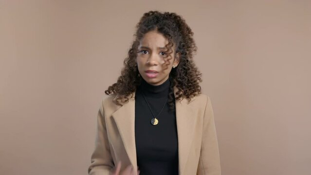 African woman afraid something, shock on beige backdrop. Unbelievable, bad news.