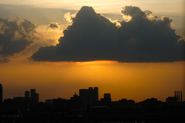 Fototapeta premium view sky and clouds over the city, sunset, sun in the clouds. beautiful with a ray of light. weather background 