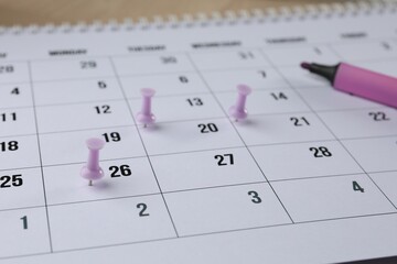 Timetable. Calendar page, drawing pins and felt pen on table, closeup