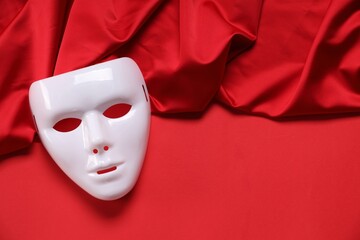 Theater arts. White mask and fabric on red background, top view. Space for text