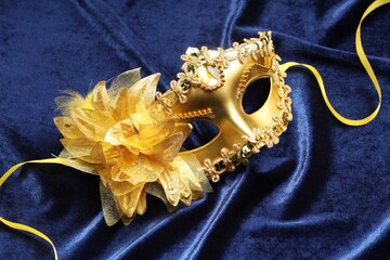 Theater arts. Golden venetian carnival mask on blue fabric, above view