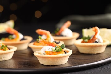 Delicious canapes with shrimps and black caviar on table, closeup