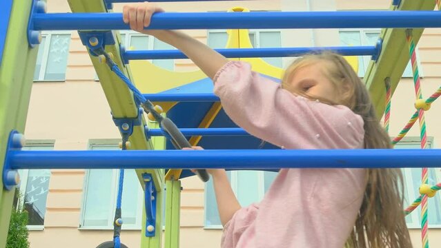Child girl playing on monkey bars
