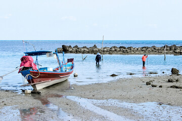 Fishermen gather on the shore during low tide, bonding over their passion for fishing and the ocean