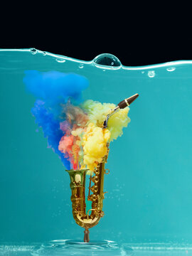 Submerged model of a toy saxophone with acrylic paint dissolving in liquid