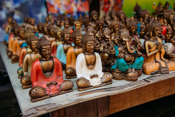 Close-up of rows of assorted brass Buddha and Ganesha ornaments on a table, Bali, Indonesia