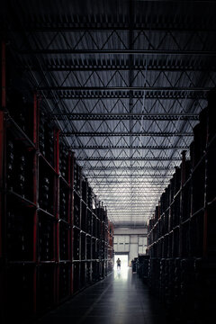 Distant silhouette of a man standing in the doorway of a tyre Warehouse, USA