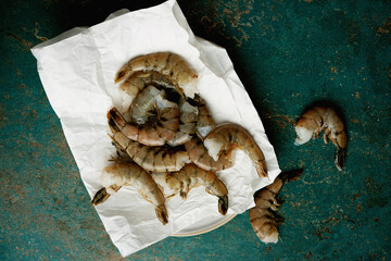 Raw shrimps on the dark rustic background