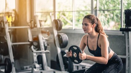 Fototapeta premium Cinematic tone of young attractive fitness woman exercise with machine in gym.