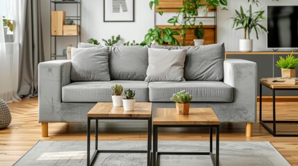 Stylish gray fabric sofa with wooden legs and two distinctive coffee tables—one in light wood with black metal frame accents and the other in dark brown wood with square iron frames—placed in a spacio