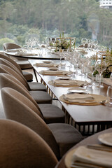 Elegant dining table set for a special event, featuring a beautiful floral centerpiece, wine glasses, and finely arranged utensils, creating a sophisticated and welcoming atmosphere.