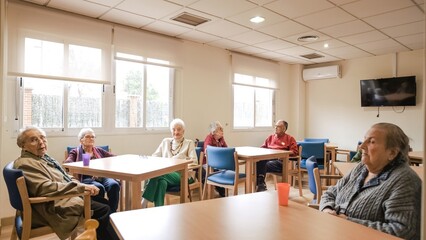Fototapeta premium Elderly men and women sitting in nursing home canteen