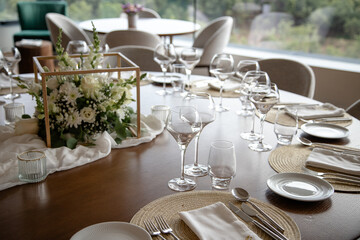 Elegant dining table set for a special event, featuring a beautiful floral centerpiece, wine glasses, and finely arranged utensils, creating a sophisticated and welcoming atmosphere.