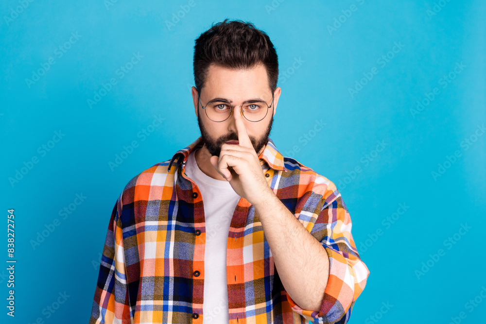 Poster Portrait of nice young man finger fix glasses wear shirt isolated on blue color background