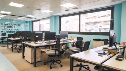 Interior of unorganized creative workspace with computer desks