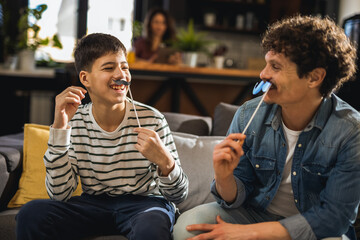 Dad and son holding fake mustache. Prostate cancer prevention