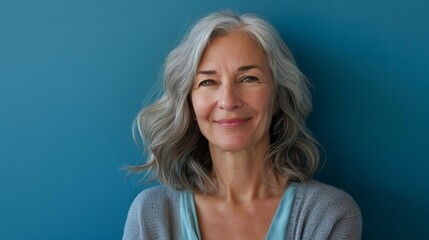 smiling middleaged woman posing confidently against blue background portrait photography lifestyle photography