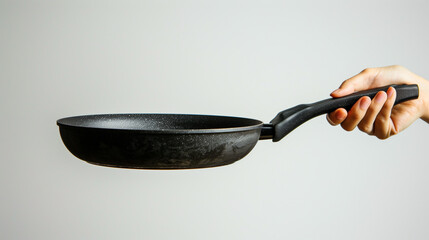 Woman's hand holding a frying pan, clearly visible detail of the hand with the black frying pan, Ai generated images
