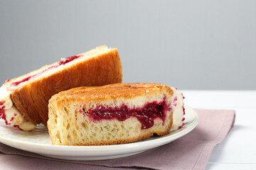 Tasty puff pastry. Round croissant with jam on table, closeup. Space for text