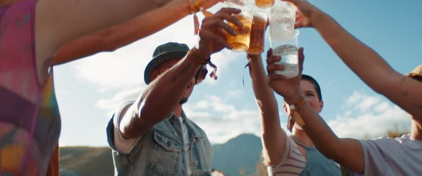 Joyful friends cheering and drinking beers at a festival