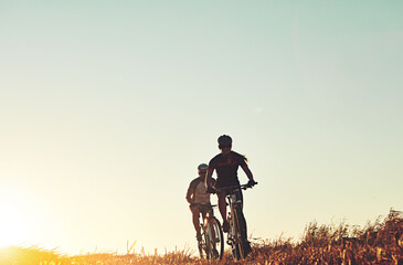 Sunset sky, people and friends on bicycle with workout, race and adventure trail in nature...