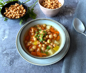 Vegetarian vegetable soup with red and yellow carrots, celery, leek, parsley and Austrian baked peas soup garnish.