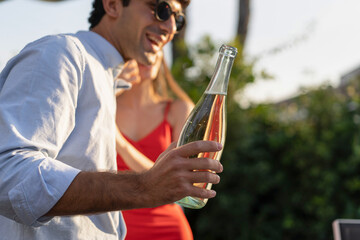 Man Holding Bottle at Outdoor Party - Celebration with Friends
