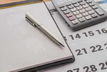 Background image with calendar , note , calculator  and pen on the desk . 