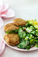 Quinoa cutlets and mixed salad with avocado and radishes, kiwi and water with lemon, delicious hearty breakfasts, vegan lunch plate