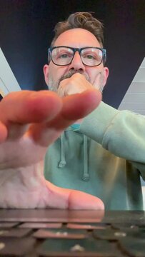 Laptop camera view pov of adult man at work on computer writing and typing on keyboard with concentrated expression. People online work. Workplace and modern businessman. Emails notification message