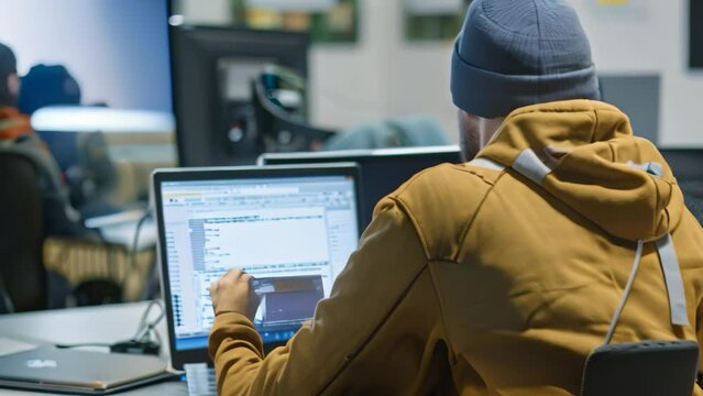 A man sitting in front of a laptop computer, focusing on work, A social engineering expert training employees to recognize phishing attempts