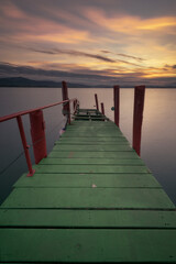 Obraz premium Old wooden walkway used as a pier painted in striking colors, green and red, in Puntal de Somo, Santander