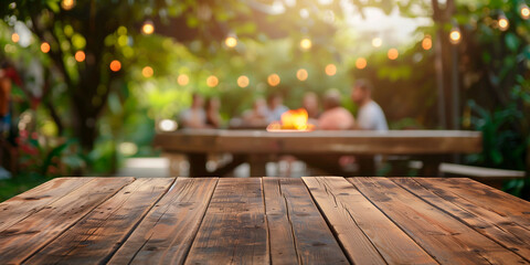 Empty wooden table and blurred view of people having BBQ barbecue with modern grill outdoors