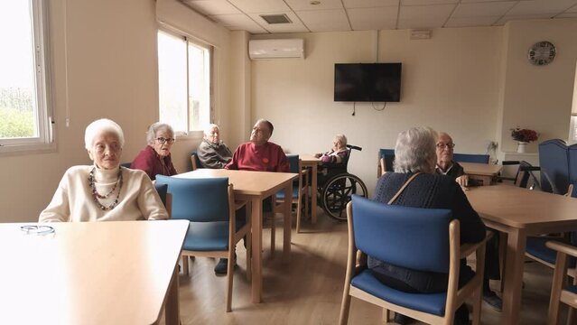 Elderly men and women in nursing home canteen