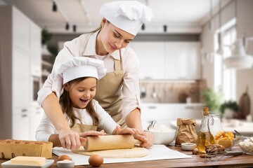 Happy Mom And small Daughter Cooking Together In Kitchen