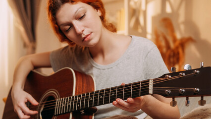 Guitar playing. Music hobby. Inspired musician girl enjoying performing on string acoustic...