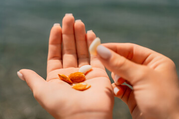 A hand holding a handful of almonds