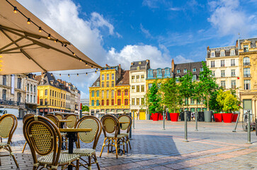 Fototapeta premium La Grand Place square in Lille city center, Flemish mannerist architecture style buildings, trees in pots, tables and chairs of street restaurant, French Flanders, Nord department, Northern France