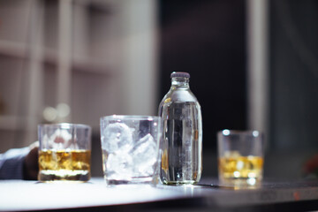 glass of alcohol is left on table after drinking with friends in office after work so that alcohol helps relax mind. Concept of ​​drinking alcohol in moderation and campaigning against drunk driving.