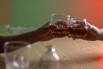 A group of businessmen held brandy glasses together to cheers glasses of brandy after concluding negotiations on business ventures and reaching a satisfactory agreement for joint business profits.