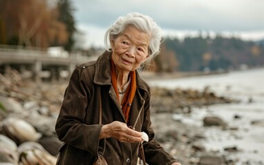 Serene Day at the Beach: Elderly Asian Woman Collecting Seashells in Coastal Environment